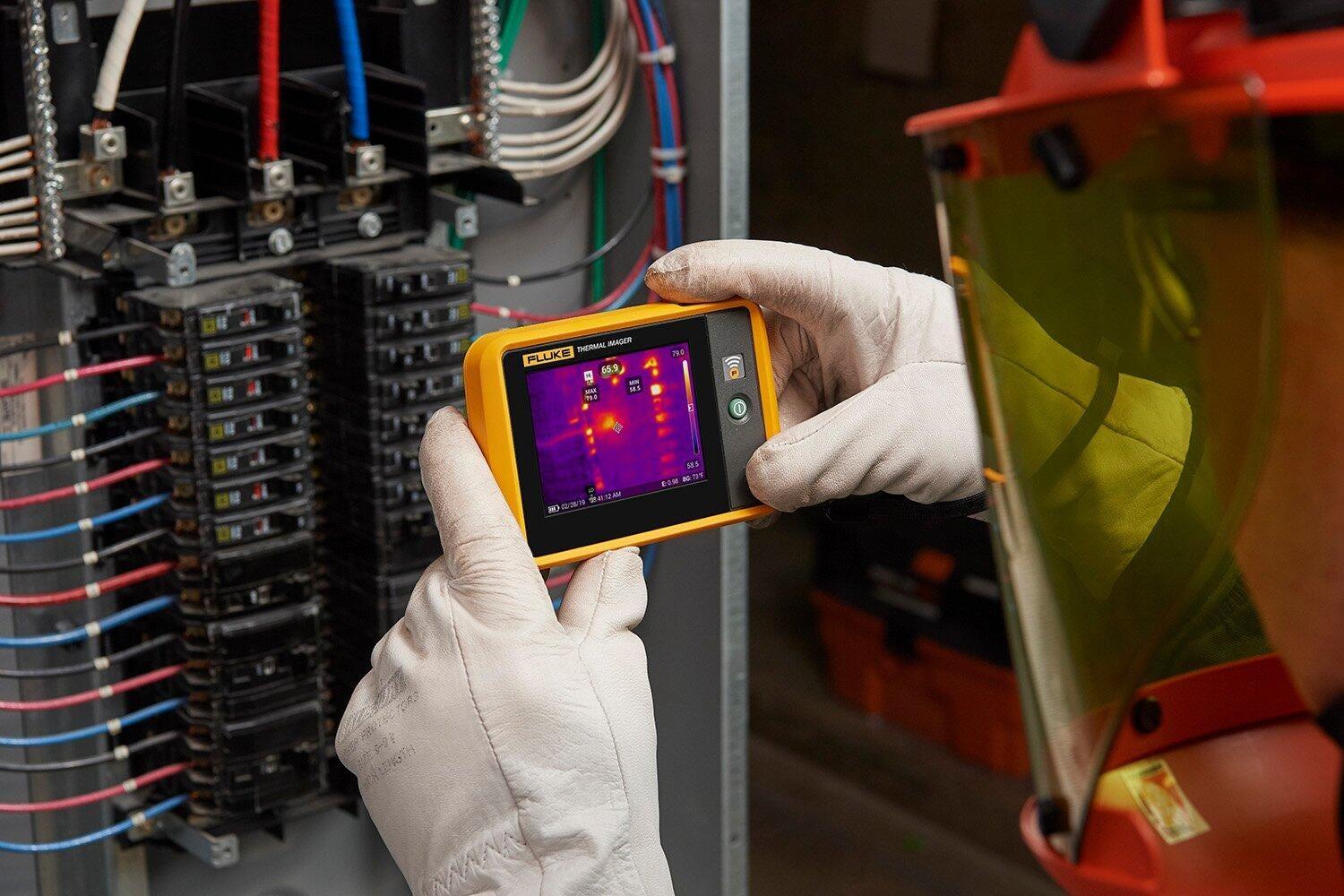 Técnico con cámara termográfica en cuadro eléctrico
